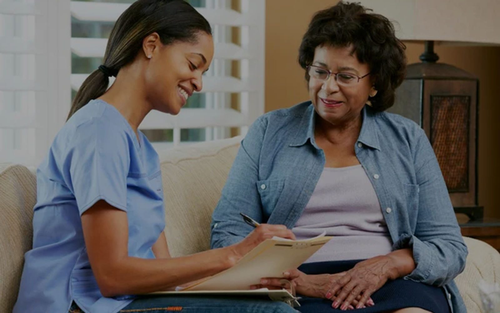 Caregiver taking notes during a home visit